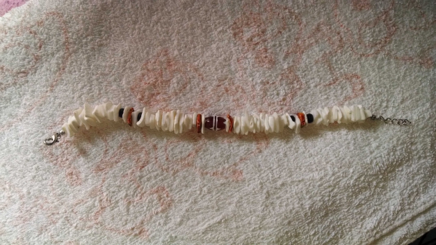 Weißes Armband mit brauner Perle