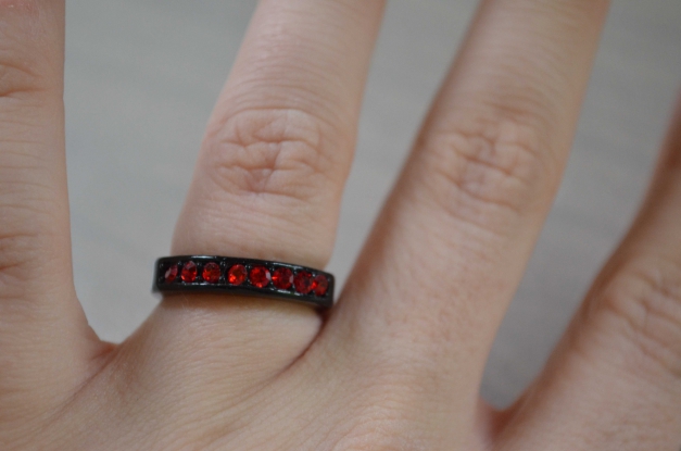 Schwarzer Ring mit roten Steinen