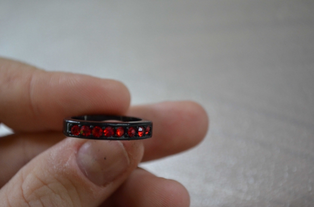 Schwarzer Ring mit roten Steinen
