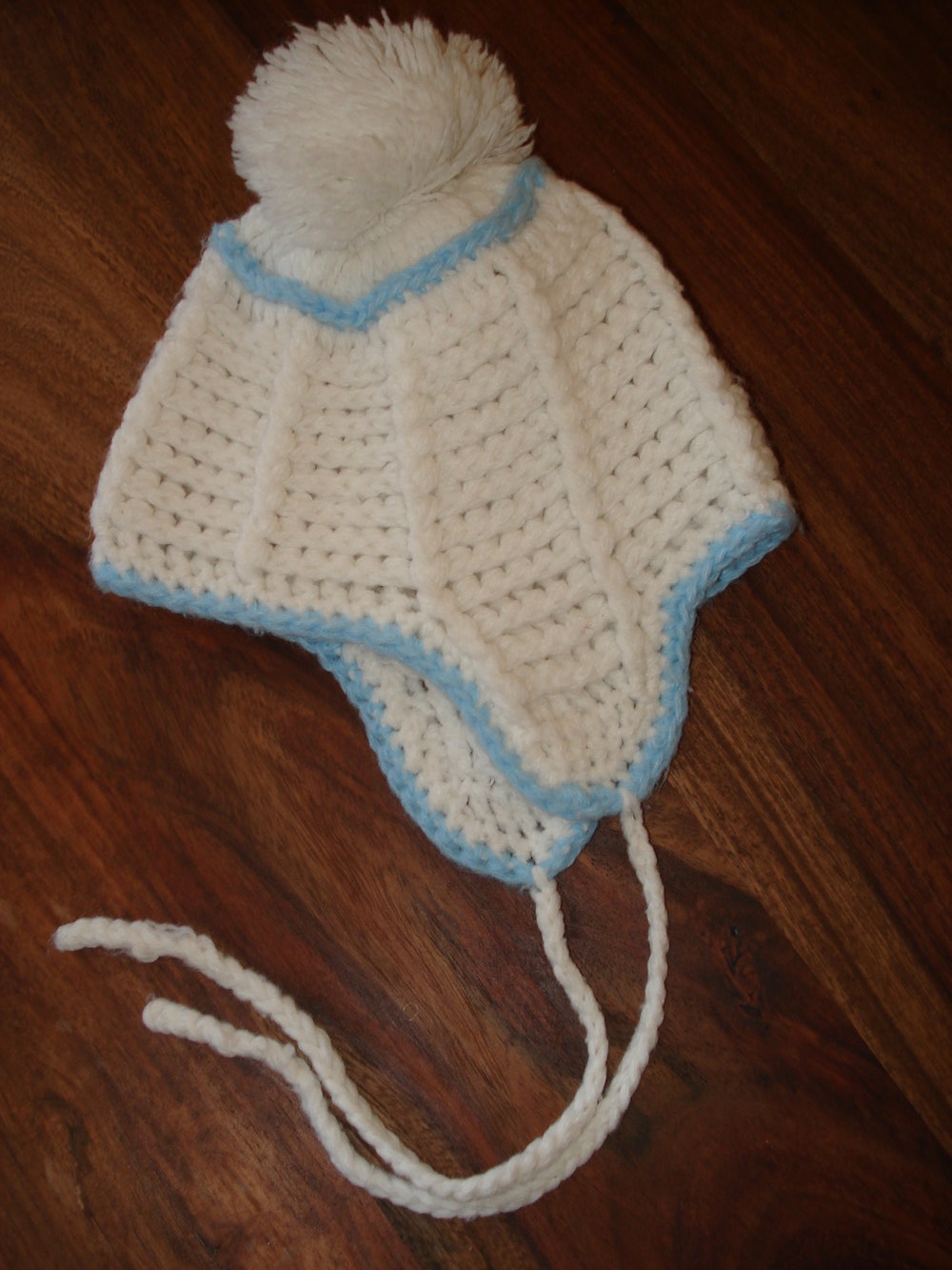 weiß-blaue Strickmütze mit Bommel