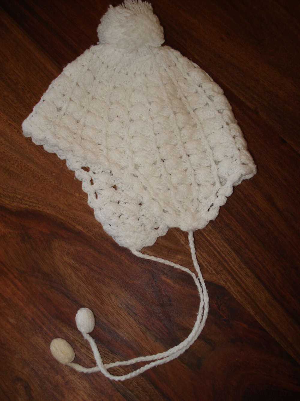 weiße Strick-/Häkelmütze mit Bommel