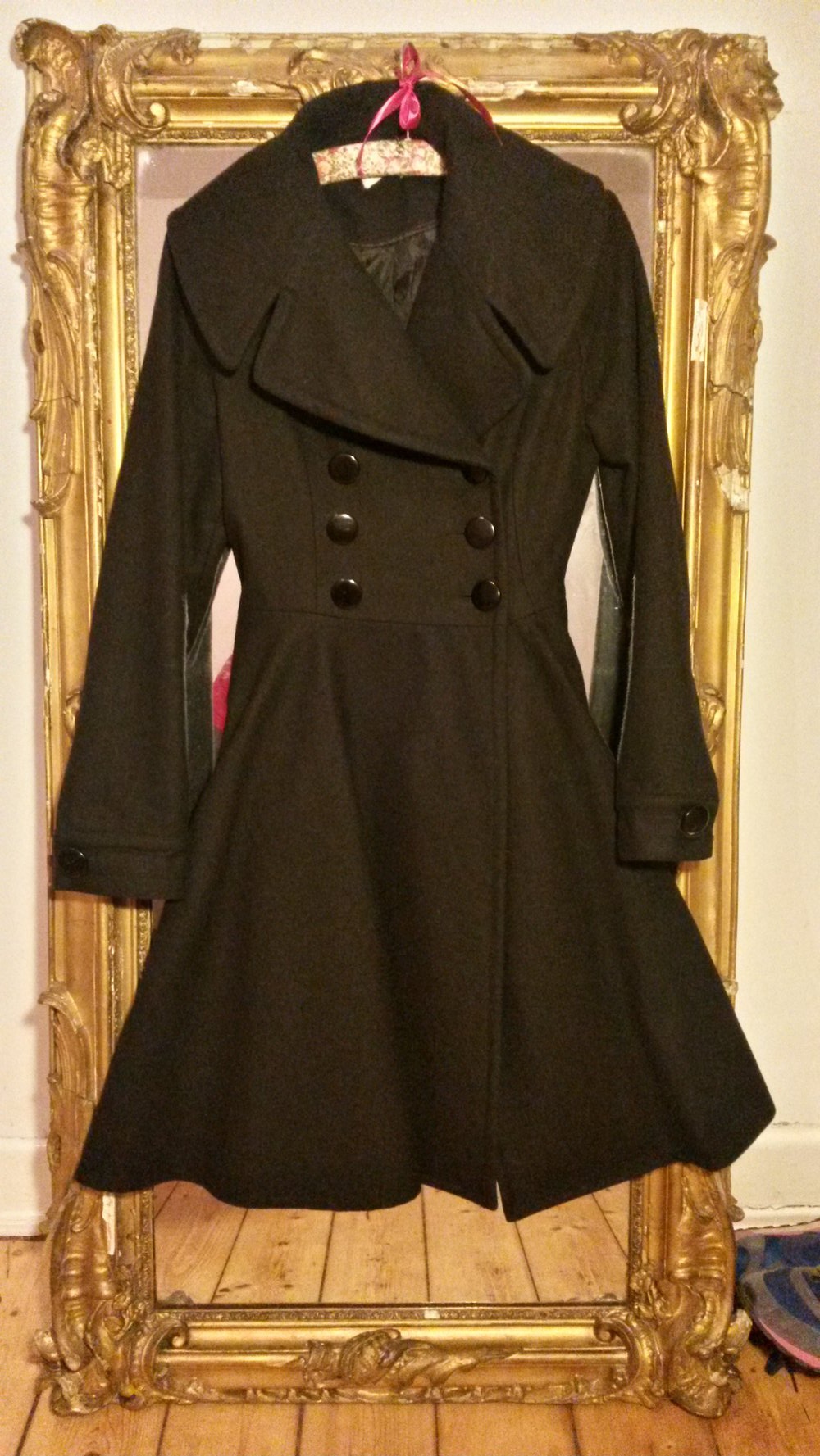 Eleganter, ausgestellter schwarzer Wintermantel im altmodischen Stil