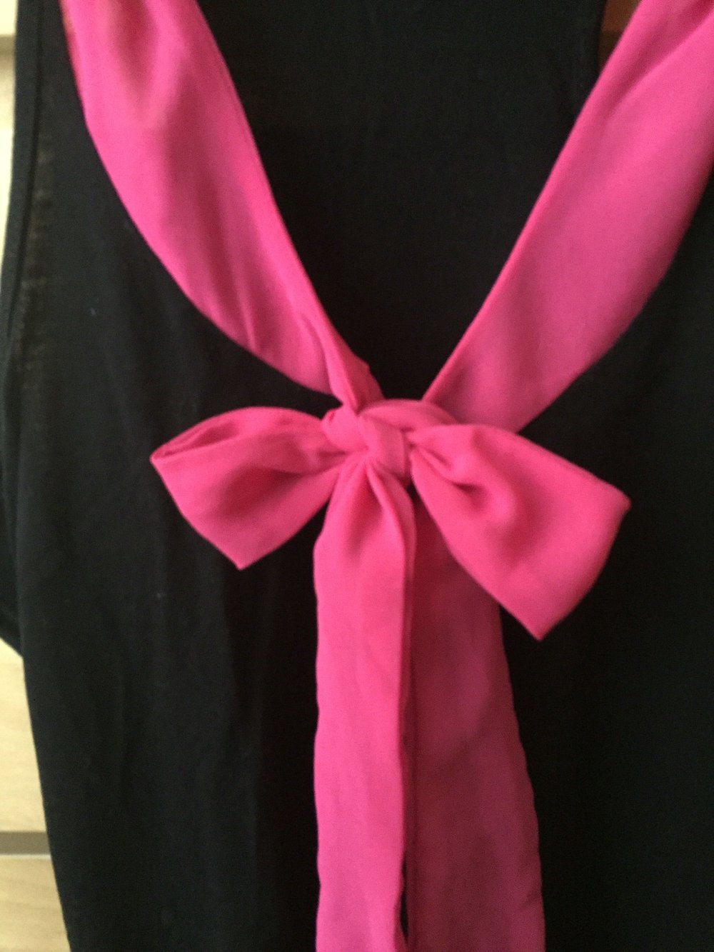 Schwarzes Top mit pinker Schleife