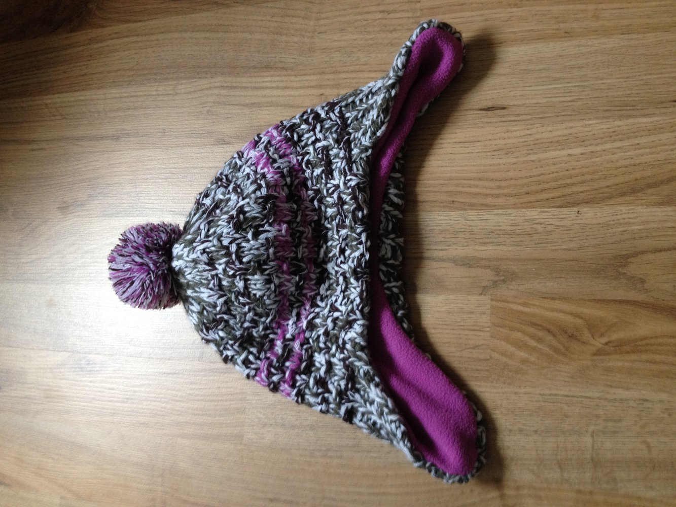 Grau- weiß- lila Bommelmütze