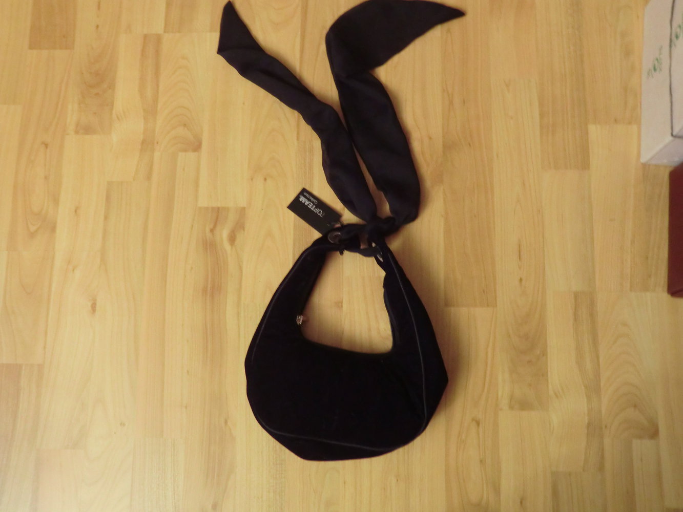 Kleine schwarze Handtasche mit Etikett