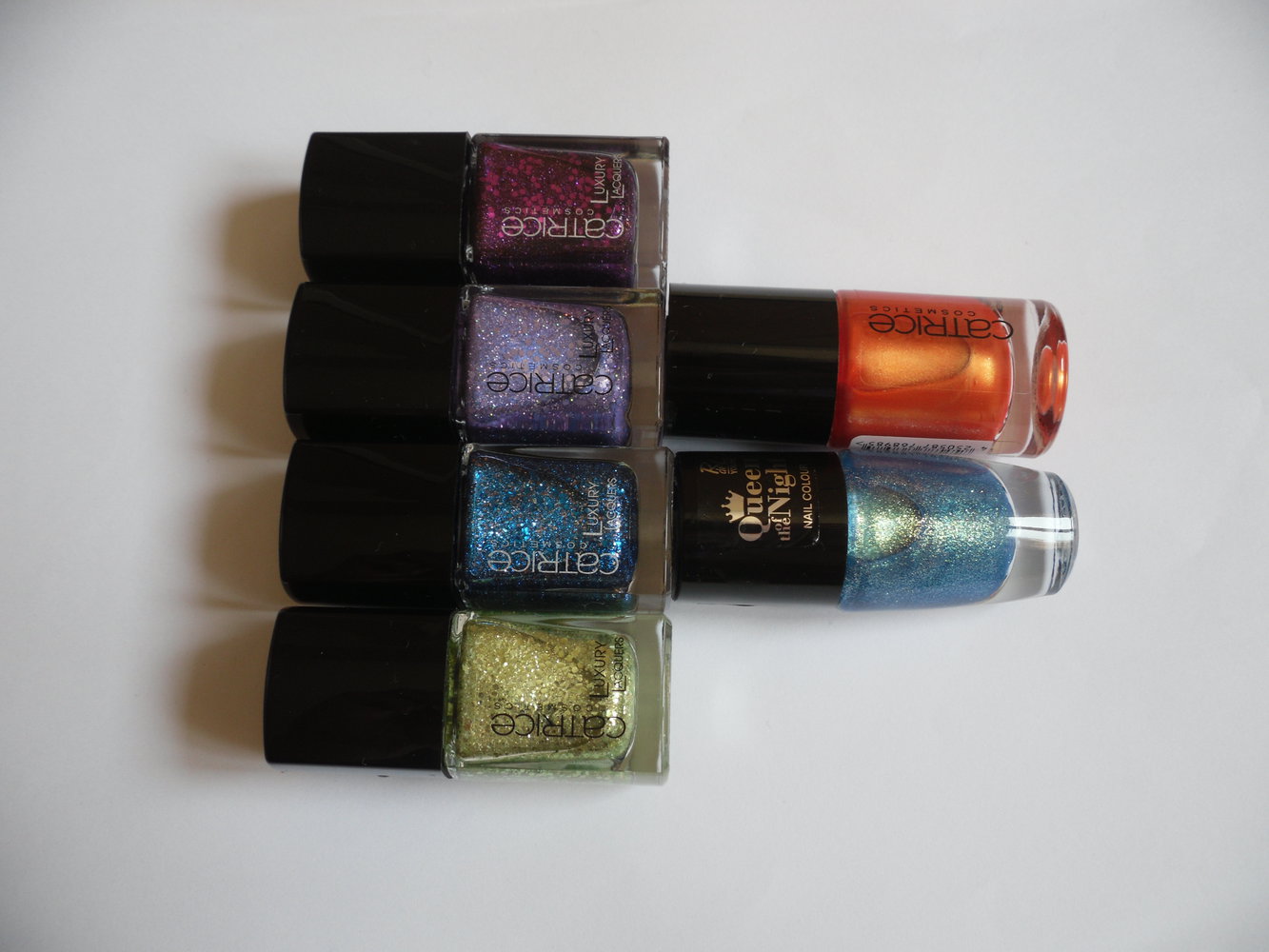 Verschiedene Glitzernagellacke in blau, grün, violett, orange