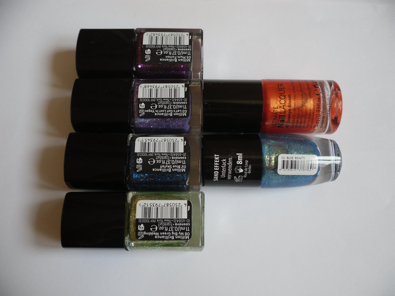 Verschiedene Glitzernagellacke in blau, grün, violett, orange