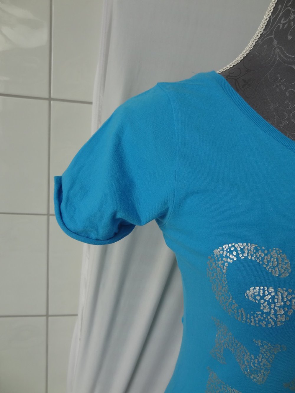 Blaues T-Shirt mit silberner Aufschrift 