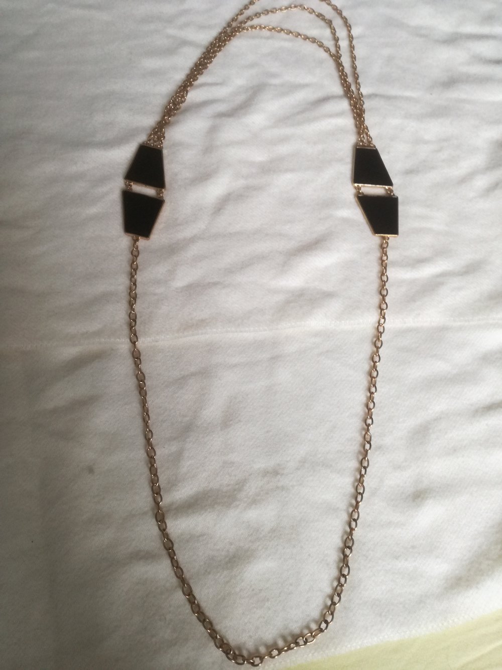 Goldene Kette mit schwarzen Elementen