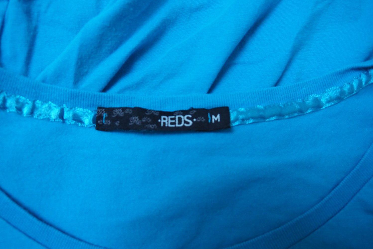 Blaues T-Shirt mit silberner Aufschrift 