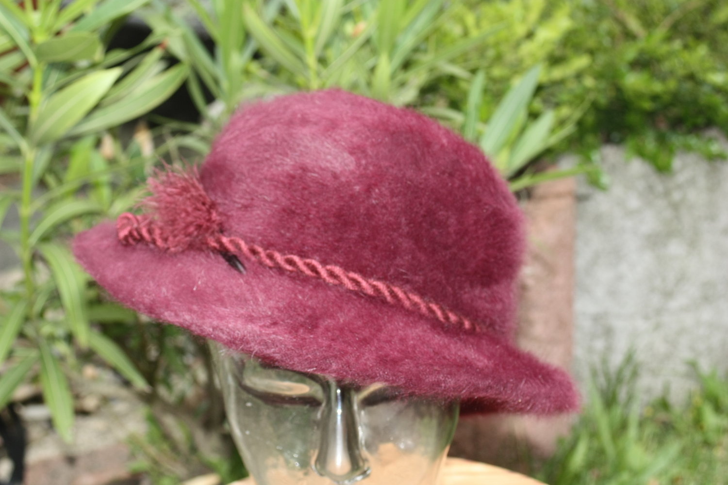 Lila-farbener Hut mit Feder seitlich. Gr. 57