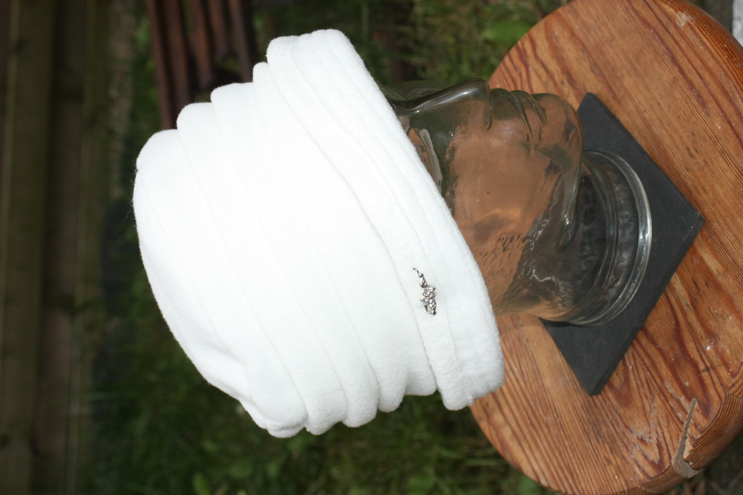 Wegener Mütze mit Raffung in weiß, waschbar bei 30°C, mit kleinem Anstecker seitlich, Gr. 57