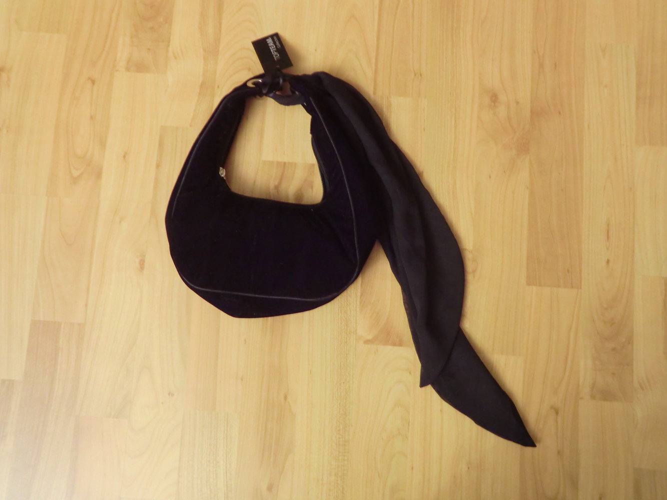 Kleine schwarze Handtasche mit Etikett