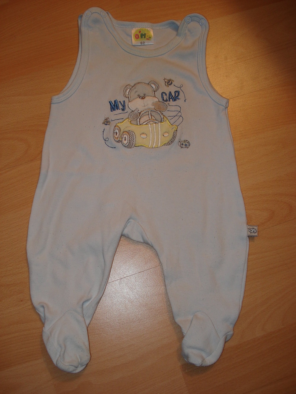 hellblauer Strampler mit aufgesticktem autofahrenden Bärchen