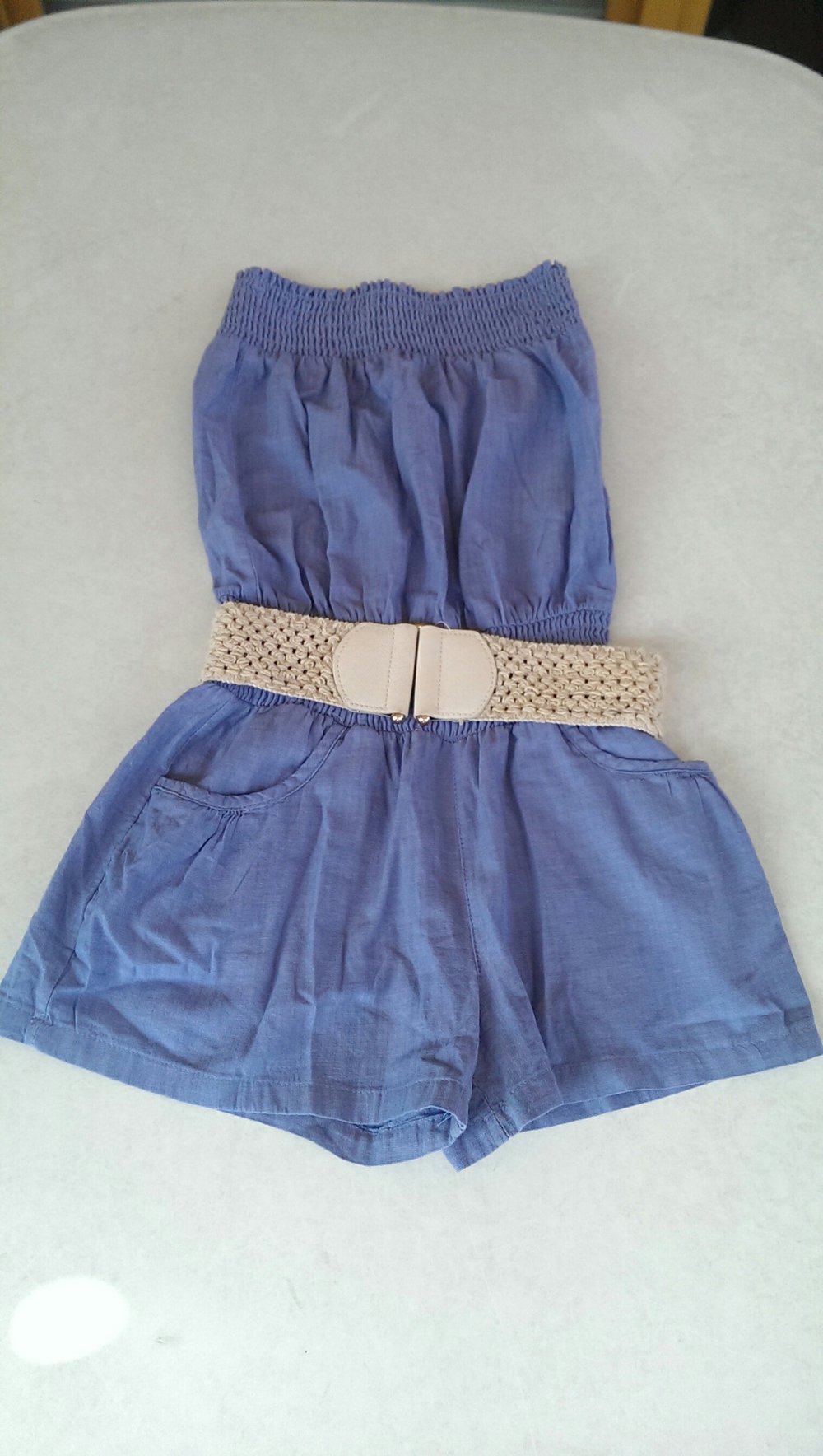 Blauer trägerloser Jumpsuit mit weißem Gürtel