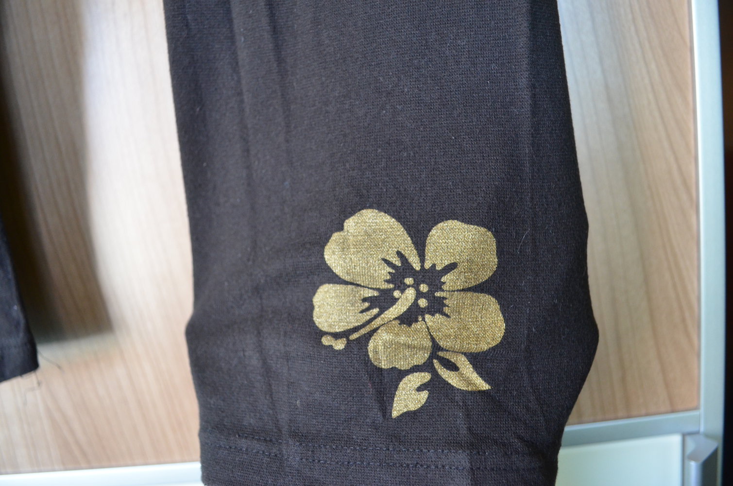 Trigema schwarze Leggings mit goldener Hawaii-Blume
