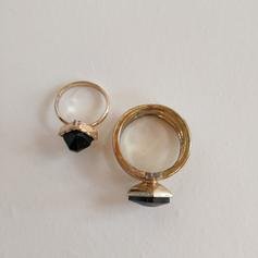 Zwei goldfarbene Ringe mit schwarzem Stein