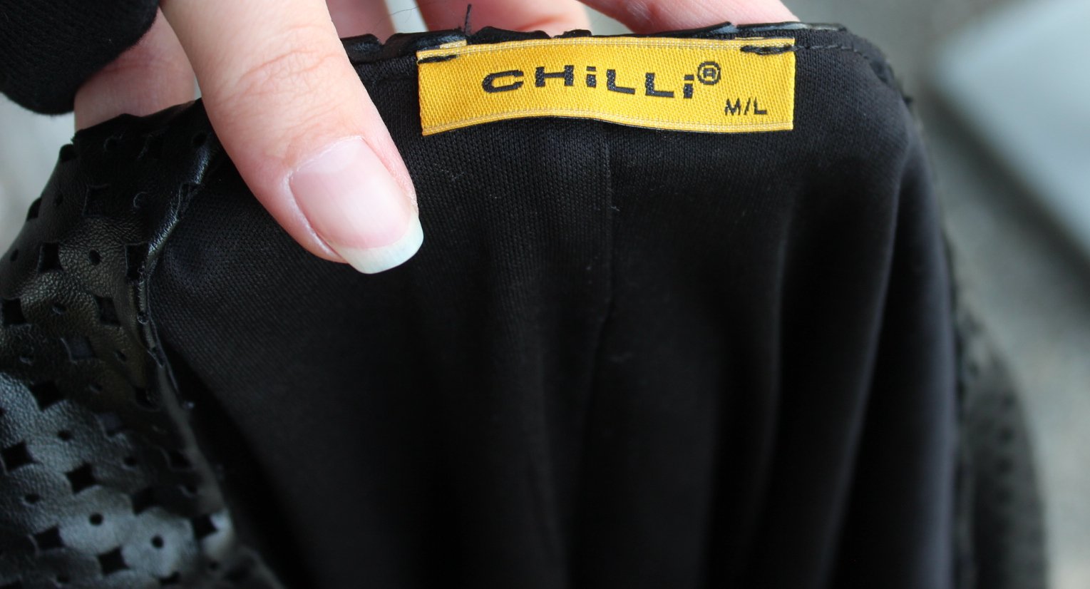 schwarzes kurzes Kleid aus Kunstleder mit Kreisen & Lochmuster, ca. Größe 38