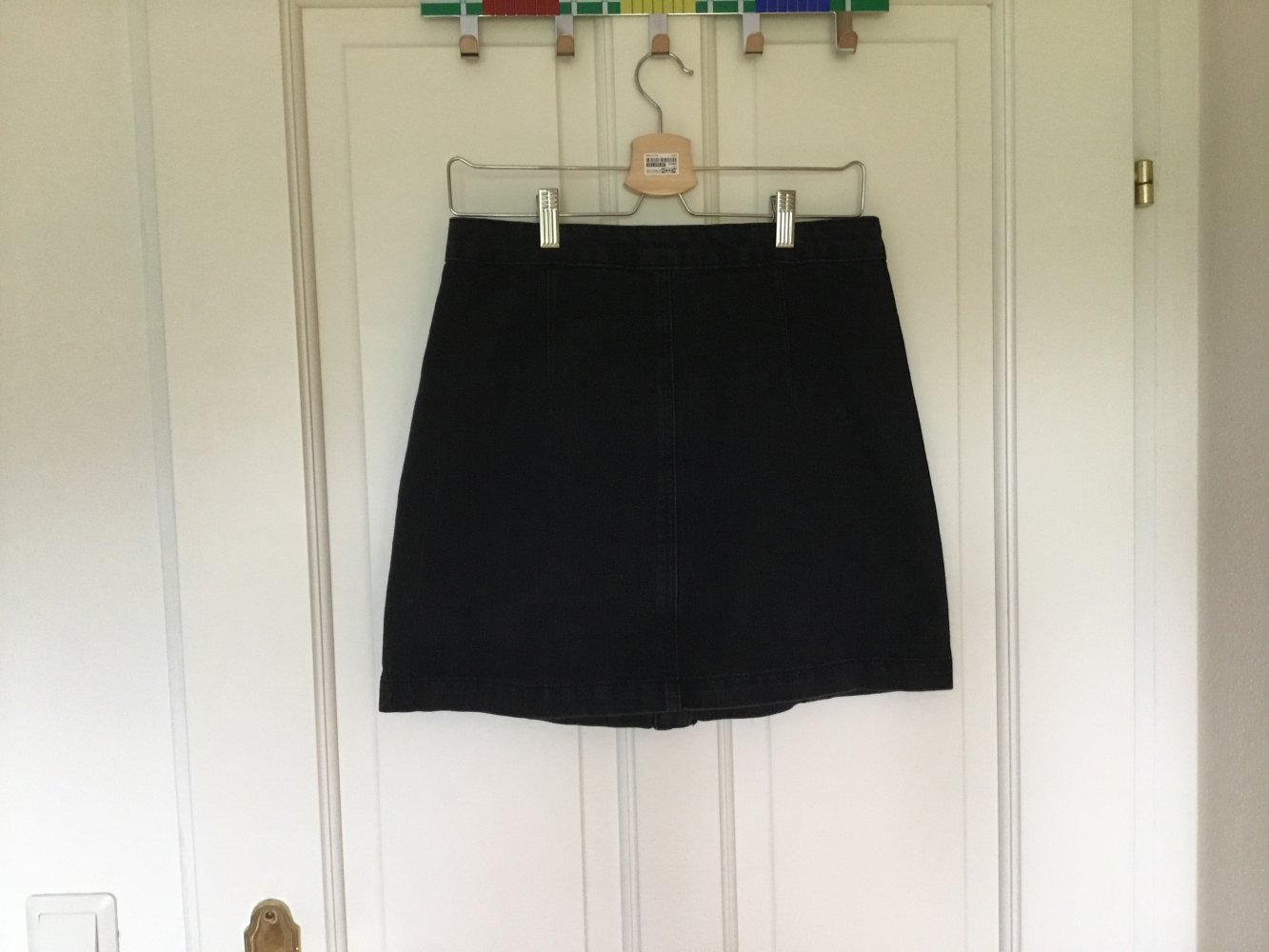 Moderner schwarzer Jeansrock mit Knopfleiste