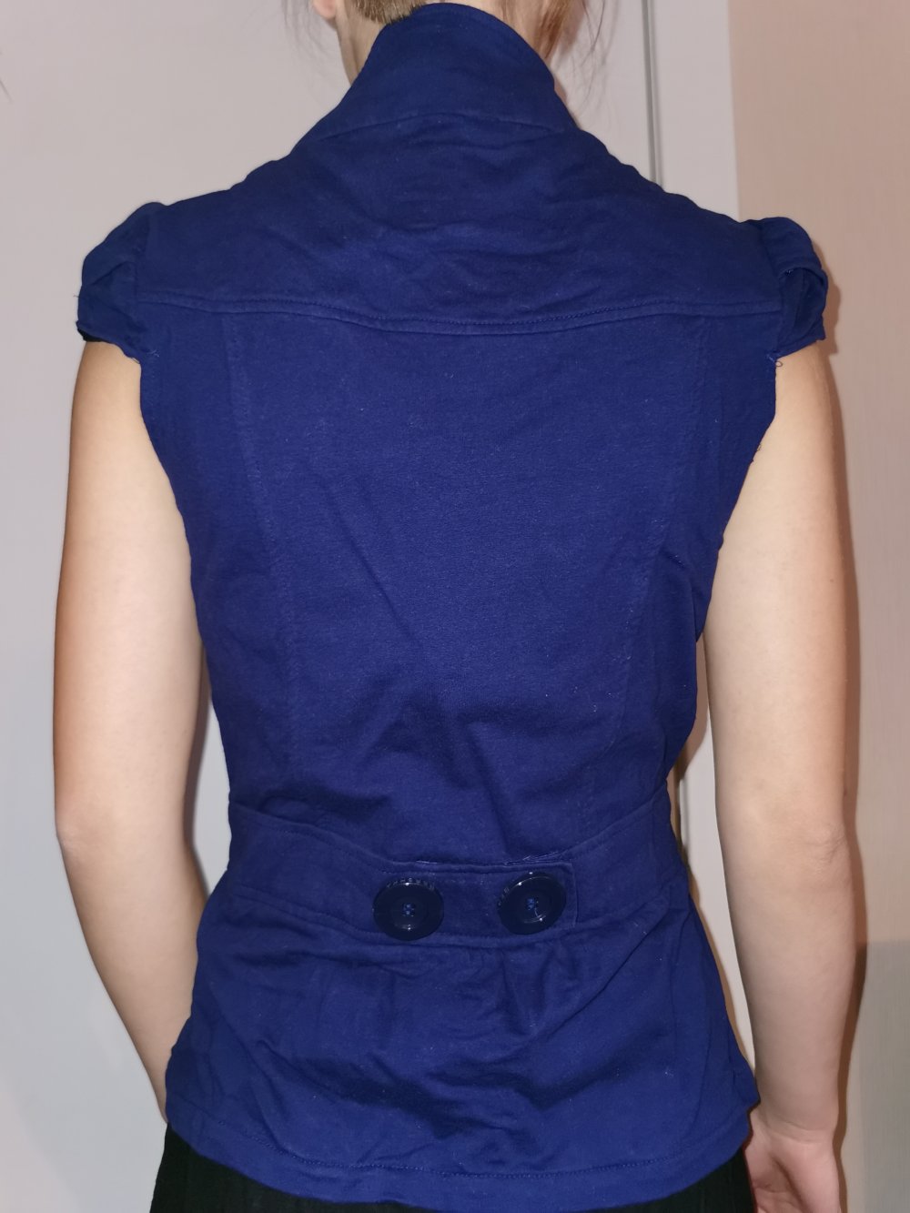 blaue Weste mit großen Knöpfen