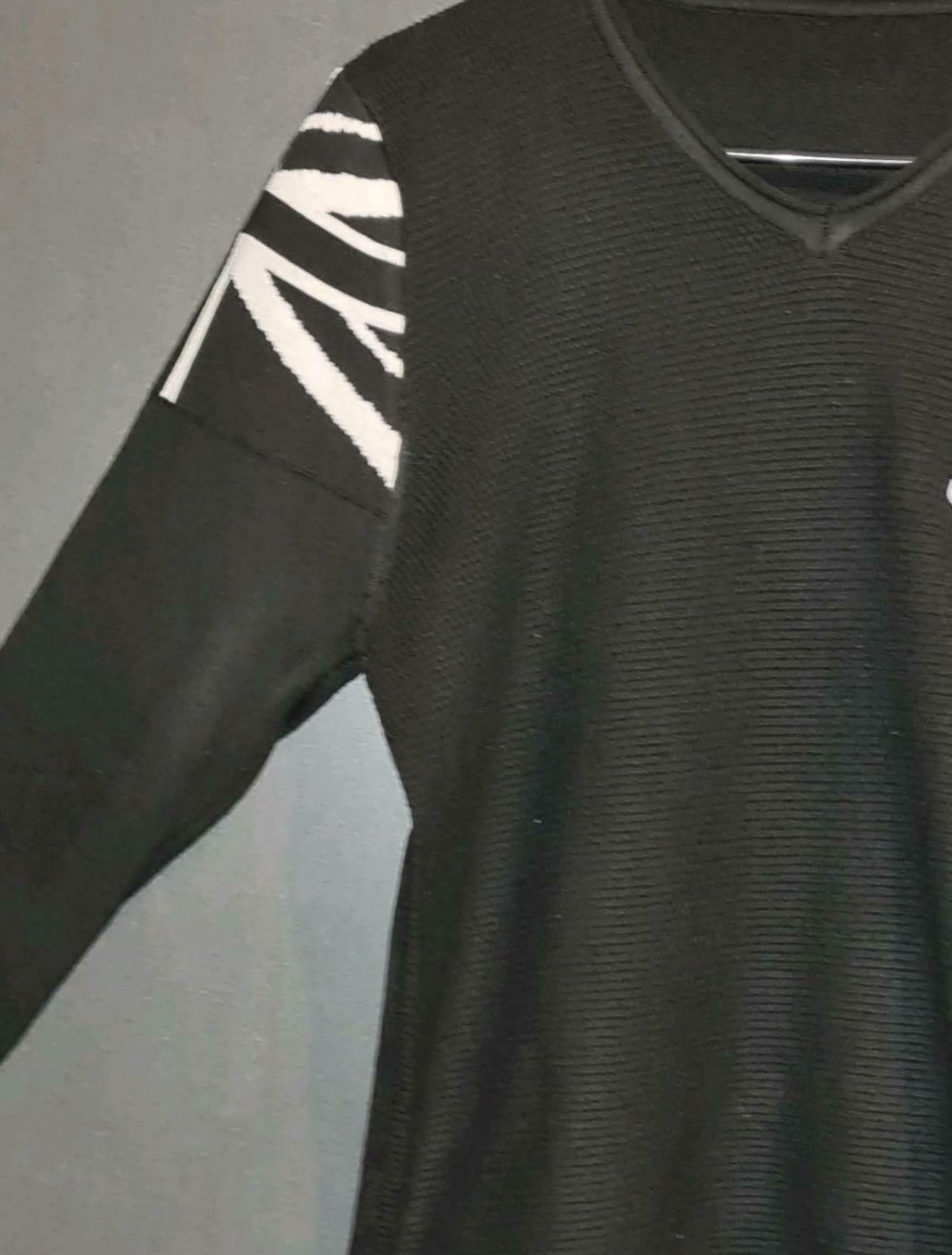 Schwarzer Pullover mit weißen Applikationen