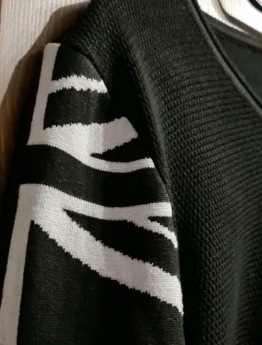 Schwarzer Pullover mit weißen Applikationen