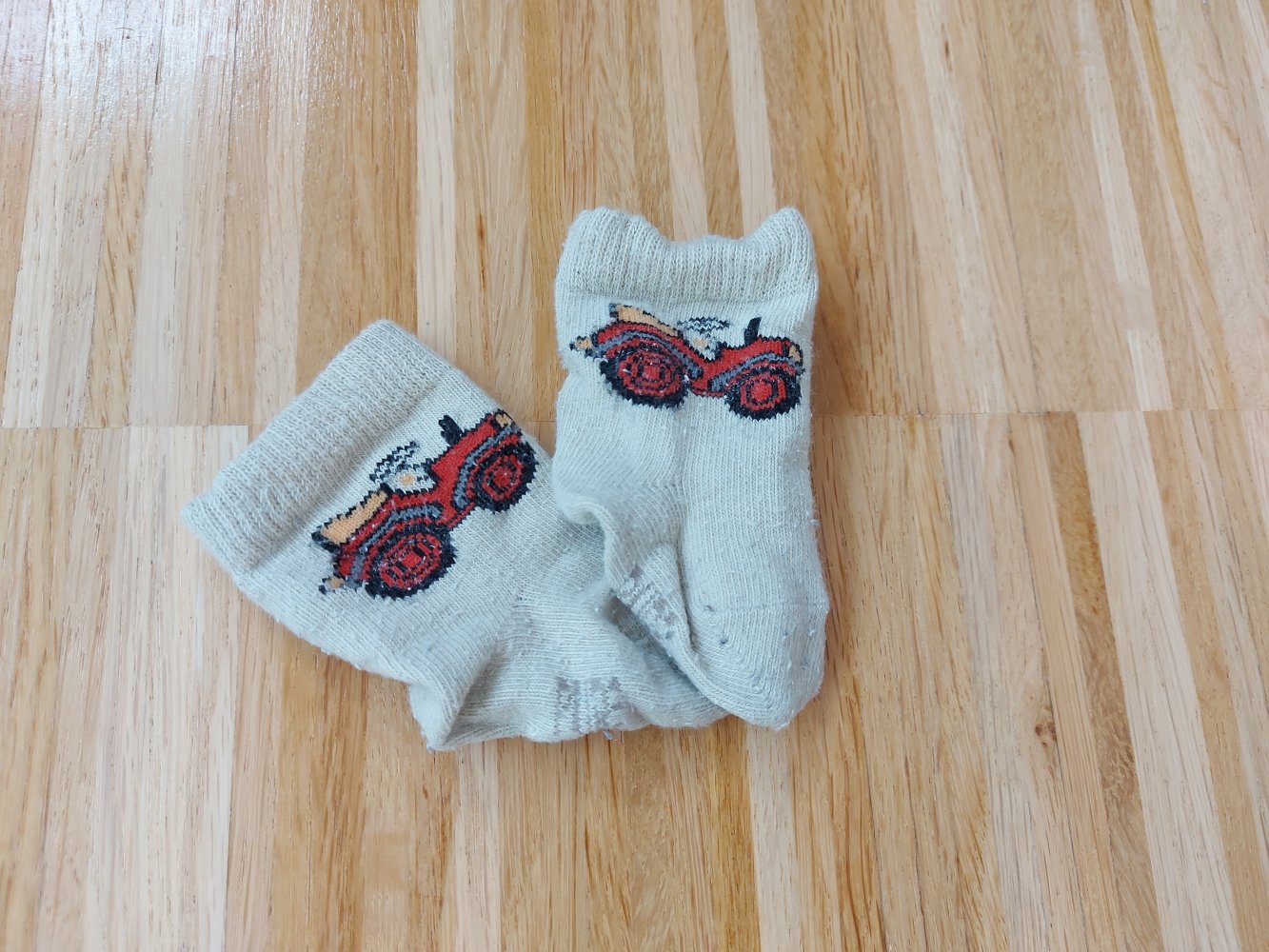 beigefarbene Babysöckchen mit Traktor