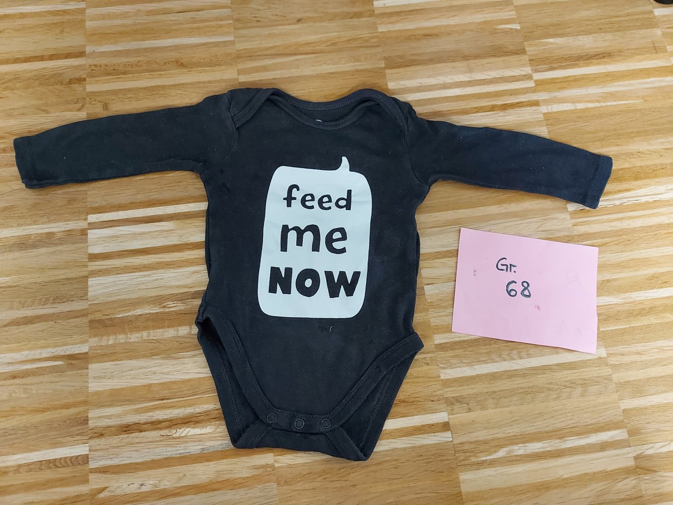 schwarzer Langarmbody Gr. 68 mit Sprechblase feed me now