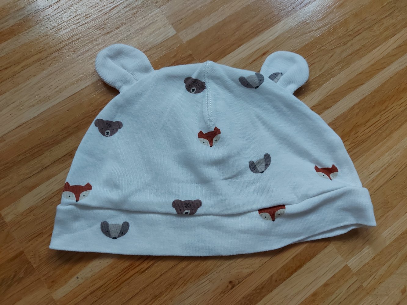 weiße Babymütze mit Öhrchen und Bär- und Fuchsmotiven
