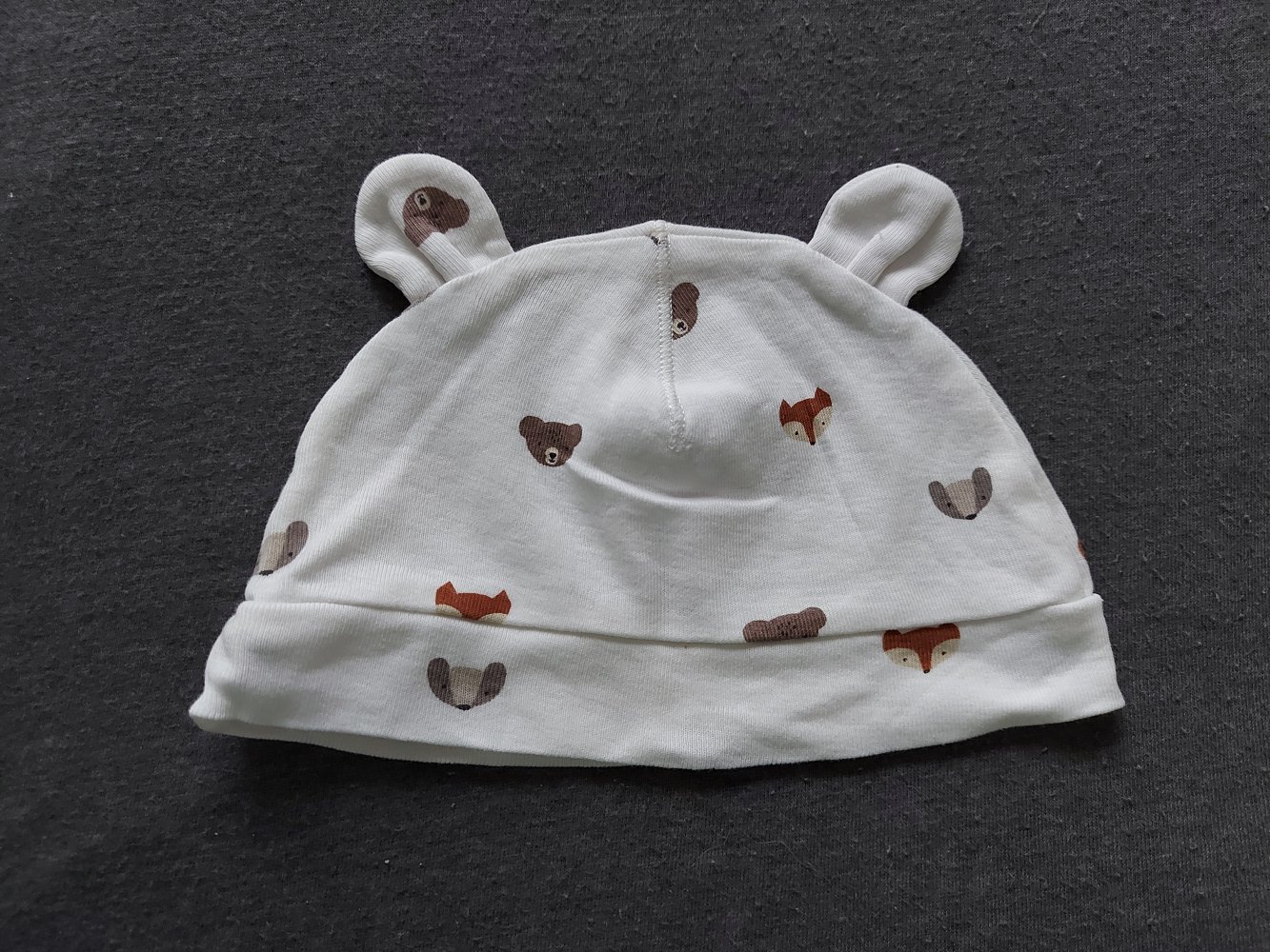 weiße Babymütze mit Öhrchen und Bär- und Fuchsmotiven