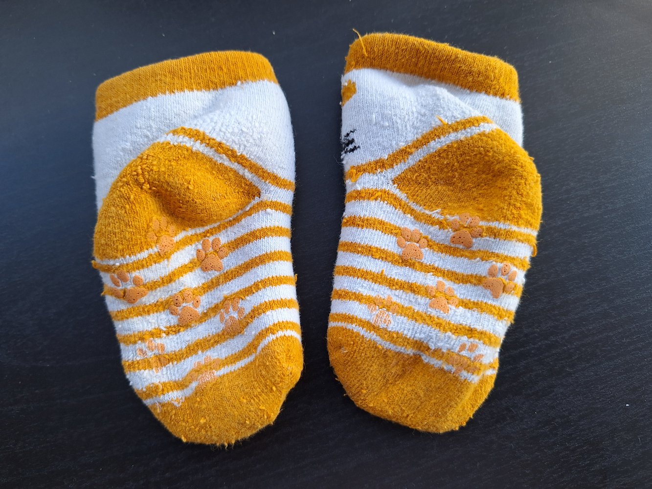 Weiß-orange Babysocken mit Stoppernoppen in Pfotenform