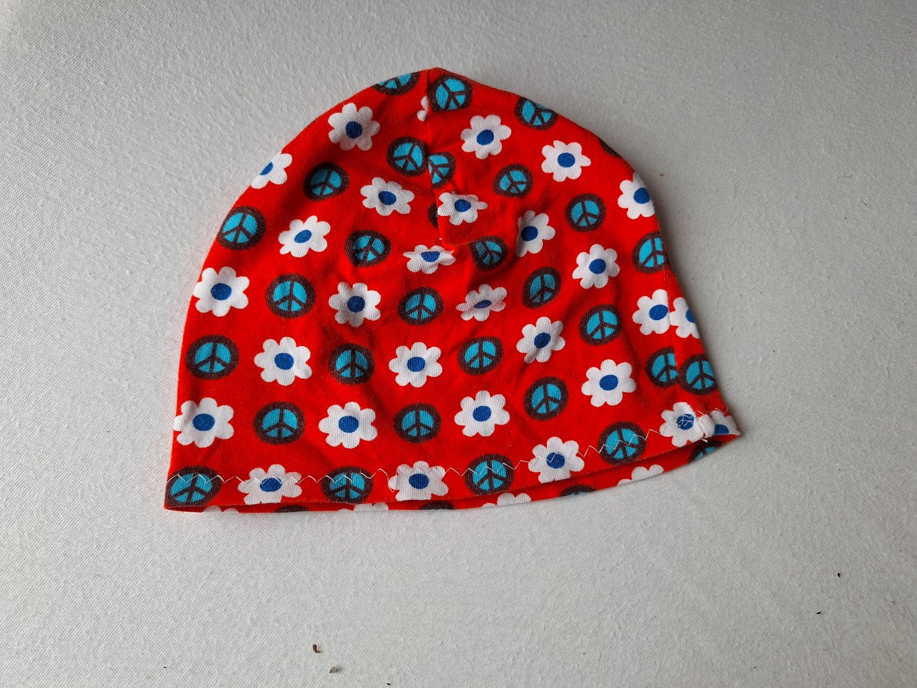 rote Babymütze mit Peace-and Flowers