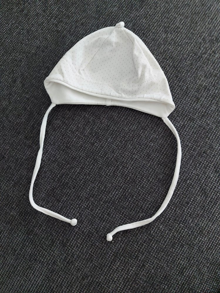 weißes gepunktetes Erstlingsmützchen mit Schnüren