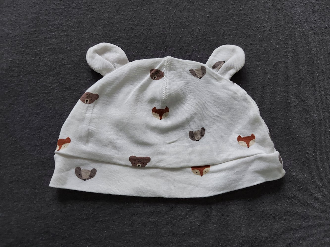weiße Babymütze mit Öhrchen und Bär- und Fuchsmotiven
