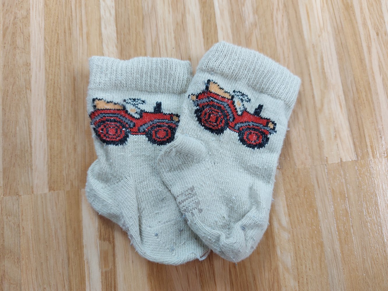 beigefarbene Babysöckchen mit Traktor